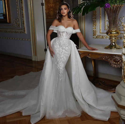 The Cosmopolitan 2 in 1 Luxurious mermaid cut wedding dress with a detachable train. Off-shoulder sleeves.

Material designer lace
Silhouette Mermaid
Designer Dovita Milano